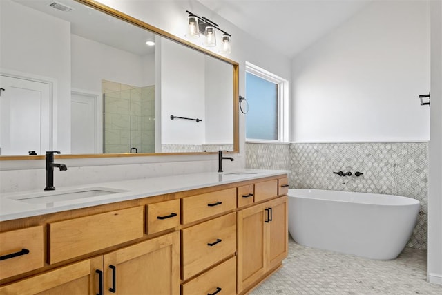 bathroom with vanity, tile walls, and shower with separate bathtub