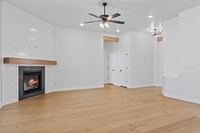 unfurnished living room featuring a fireplace, light hardwood / wood-style flooring, and ceiling fan