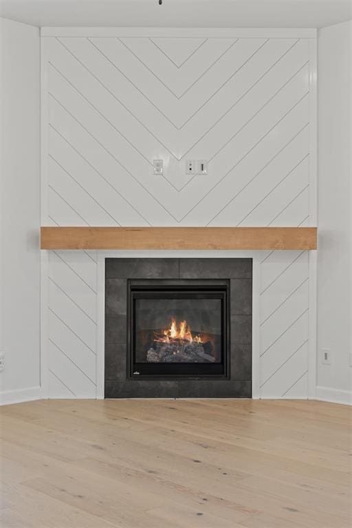 details with hardwood / wood-style floors, a fireplace, and wooden walls