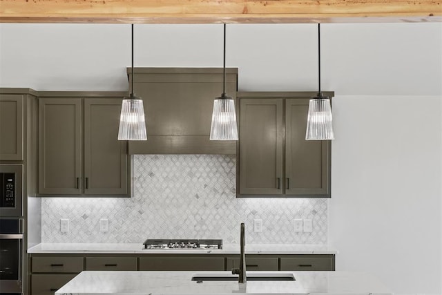 kitchen featuring backsplash, decorative light fixtures, sink, and stainless steel appliances