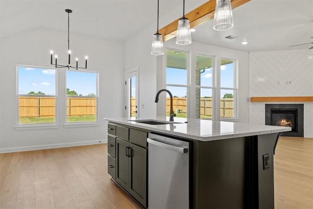 kitchen with dishwasher, sink, light hardwood / wood-style flooring, decorative light fixtures, and a kitchen island with sink