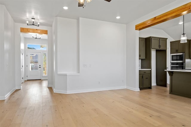 interior space featuring ceiling fan with notable chandelier, hanging light fixtures, vaulted ceiling, light hardwood / wood-style flooring, and appliances with stainless steel finishes