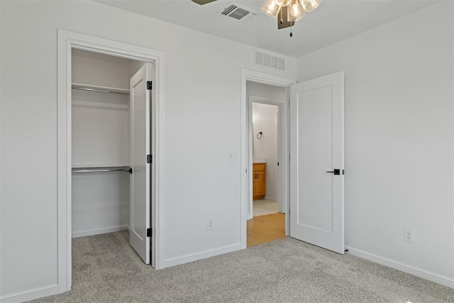 unfurnished bedroom with light carpet, a closet, and ceiling fan