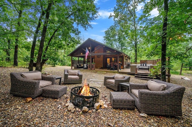 view of patio / terrace featuring a deck and an outdoor living space with a fire pit