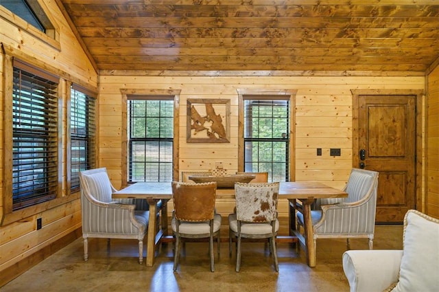 dining space featuring wooden walls and lofted ceiling