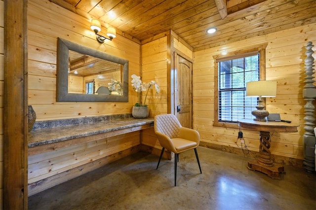 sitting room featuring concrete flooring, wood walls, and wooden ceiling