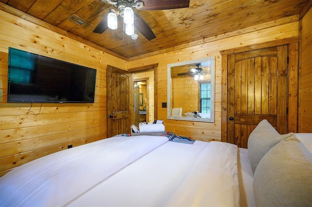 bedroom with ceiling fan, wood walls, and wood ceiling