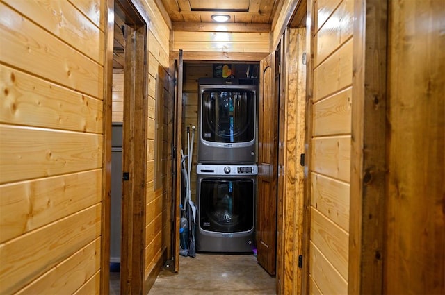 laundry room with stacked washer / dryer and wooden walls