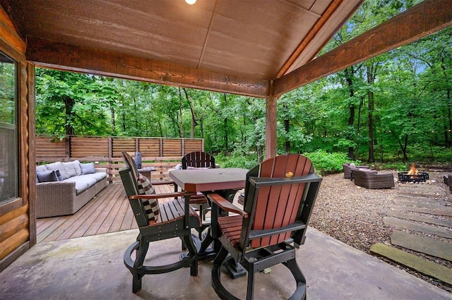 view of patio / terrace featuring a wooden deck and an outdoor living space with a fire pit