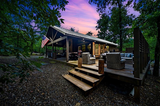 back house at dusk featuring an outdoor hangout area and a deck