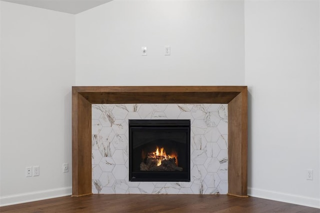 room details with hardwood / wood-style floors and a tiled fireplace