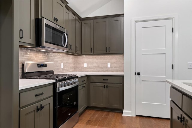 kitchen featuring gray cabinetry, backsplash, dark wood-type flooring, and appliances with stainless steel finishes