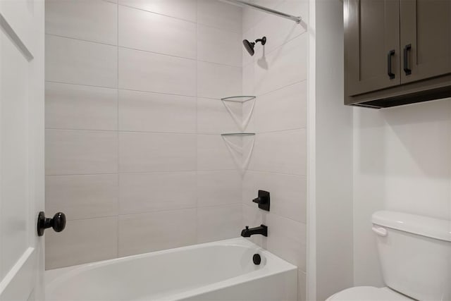 bathroom with toilet and tiled shower / bath