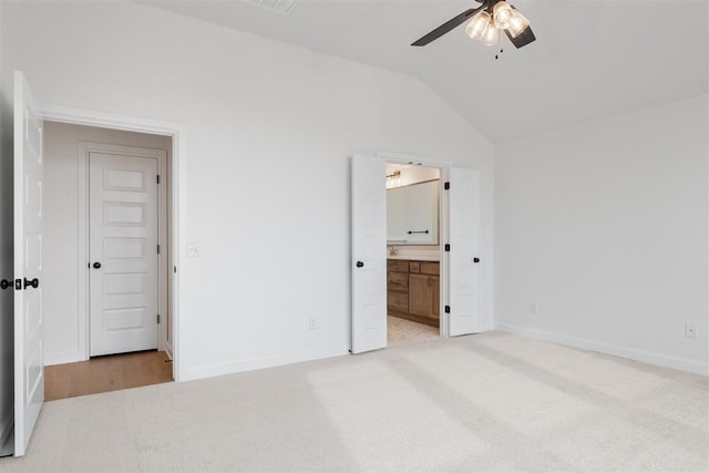 unfurnished bedroom with ceiling fan, light colored carpet, lofted ceiling, and ensuite bath