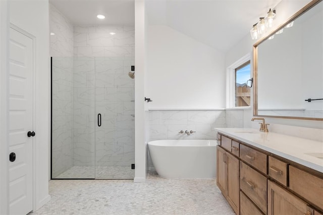 bathroom with vanity, plus walk in shower, tile patterned floors, vaulted ceiling, and tile walls