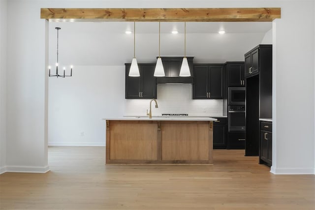 kitchen with pendant lighting, custom exhaust hood, a kitchen island with sink, beam ceiling, and stainless steel appliances