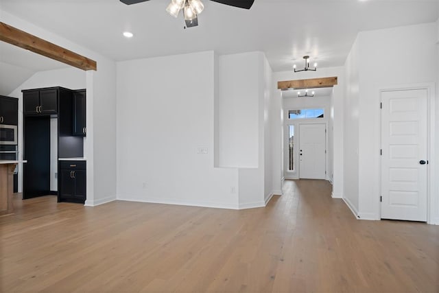 unfurnished living room with ceiling fan with notable chandelier and hardwood / wood-style flooring