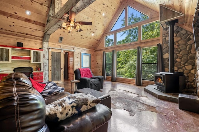 living room with a wood stove, a wealth of natural light, high vaulted ceiling, and ceiling fan