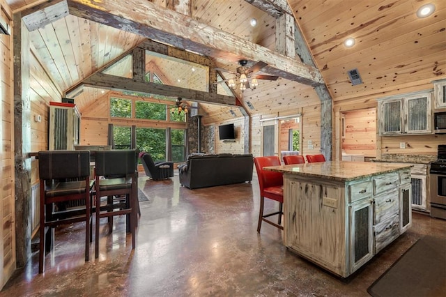 kitchen featuring appliances with stainless steel finishes, high vaulted ceiling, a kitchen island, and a healthy amount of sunlight