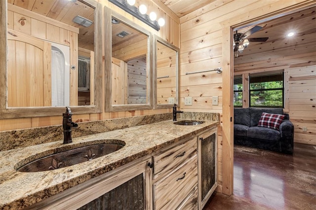 bathroom with concrete flooring, wooden walls, vanity, and wooden ceiling