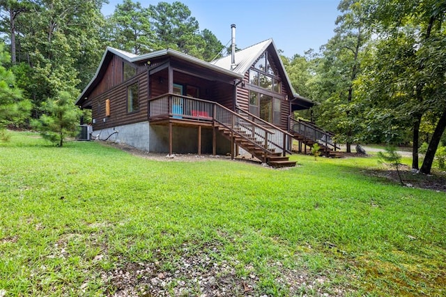 rear view of property with a wooden deck, a yard, and central AC unit