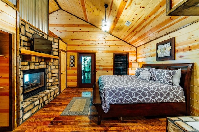 bedroom with dark wood-type flooring, wooden ceiling, a stone fireplace, wood walls, and vaulted ceiling