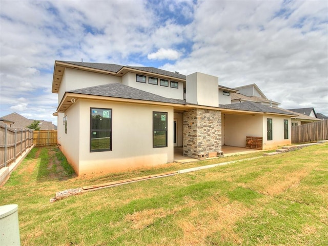 back of property featuring a lawn and a patio