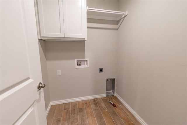 clothes washing area featuring cabinets, hardwood / wood-style floors, hookup for a washing machine, and electric dryer hookup