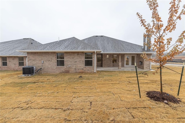 rear view of property with central air condition unit, a patio area, and a lawn