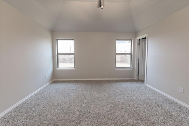 unfurnished room featuring lofted ceiling, carpet floors, and a wealth of natural light