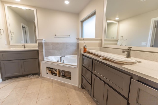 bathroom featuring tile patterned flooring, vanity, and a tub