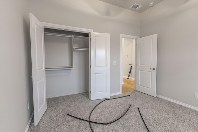 unfurnished bedroom with light carpet and a closet