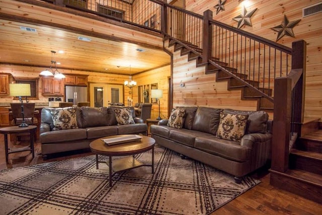 living room featuring dark wood-type flooring, a notable chandelier, wood ceiling, and a high ceiling