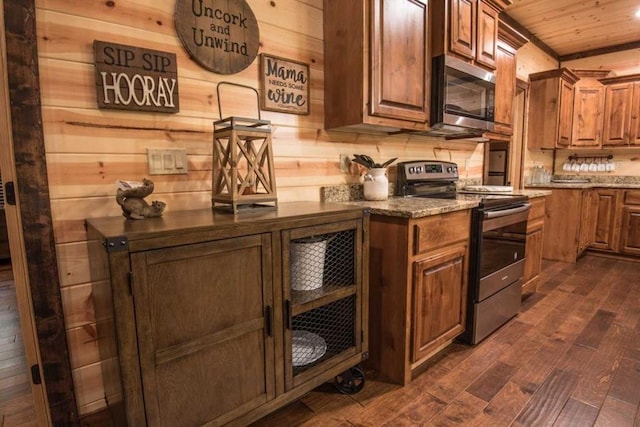 kitchen featuring wood walls, dark wood-type flooring, stainless steel appliances, dark stone counters, and wooden ceiling