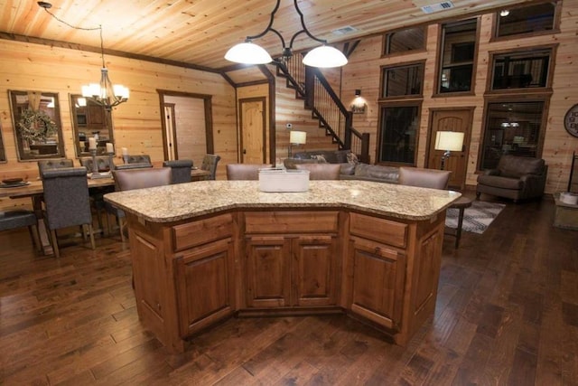 kitchen with wooden walls, wood ceiling, pendant lighting, and a center island