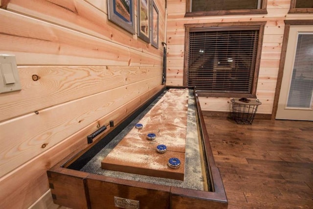 playroom featuring dark wood-type flooring and wooden walls