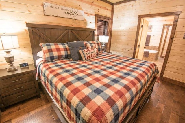 bedroom with dark hardwood / wood-style flooring and wood walls