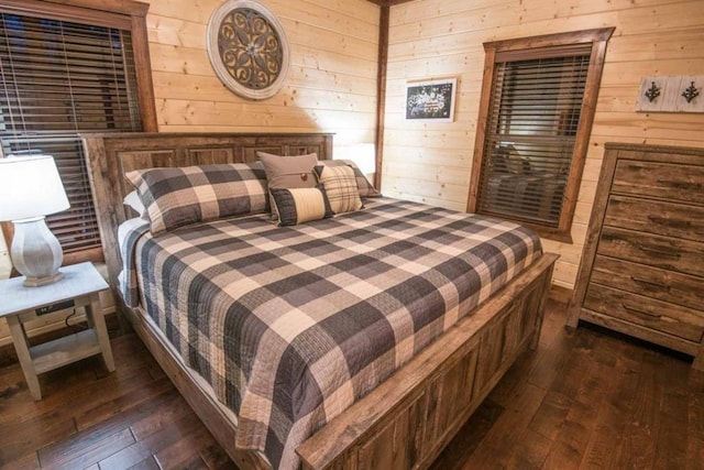 bedroom featuring dark wood-type flooring and wooden walls