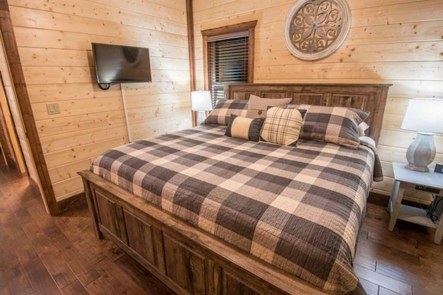 bedroom featuring dark wood-type flooring and wood walls