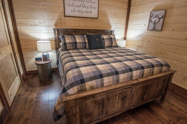 bedroom featuring dark hardwood / wood-style flooring and wood walls