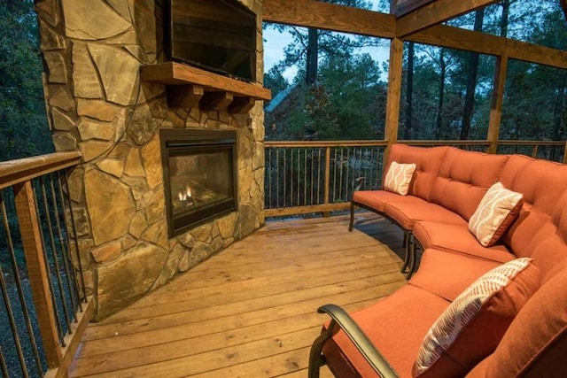 sunroom featuring an outdoor stone fireplace