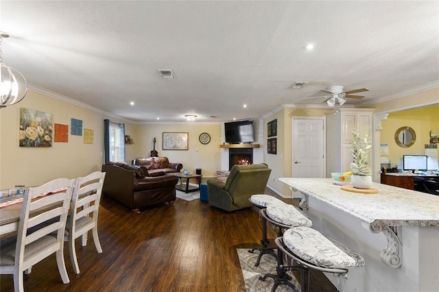 dining area with crown molding, dark hardwood / wood-style flooring, and ceiling fan