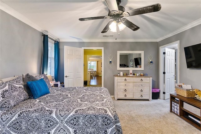 bedroom with ceiling fan, crown molding, and light colored carpet