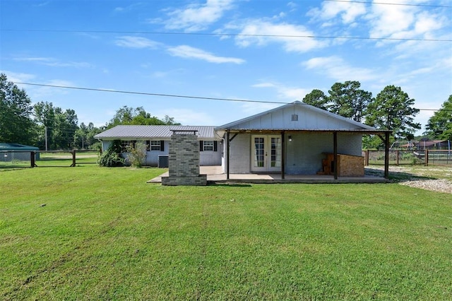 rear view of house with a yard and french doors