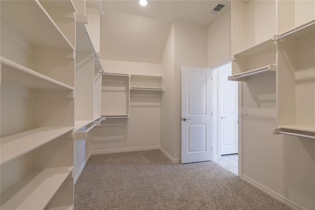 spacious closet featuring light colored carpet