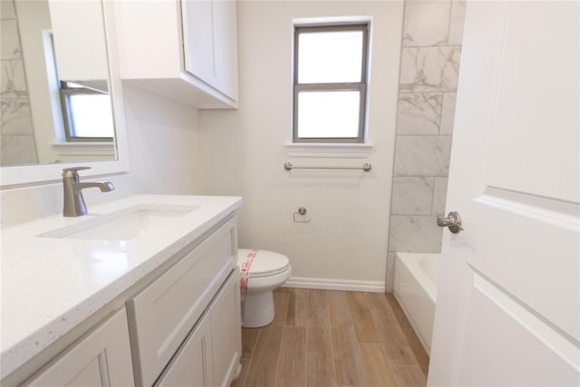 bathroom featuring vanity, wood-type flooring, and toilet