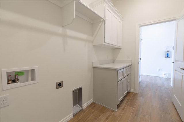 laundry room featuring cabinets, electric dryer hookup, hookup for a washing machine, and light wood-type flooring