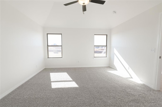 carpeted empty room featuring ceiling fan, a healthy amount of sunlight, and vaulted ceiling