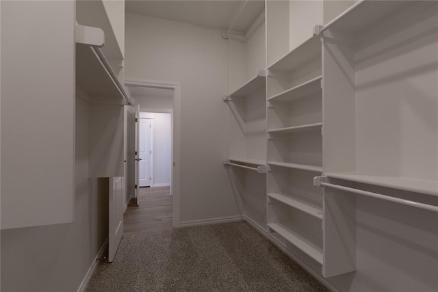 spacious closet with dark carpet