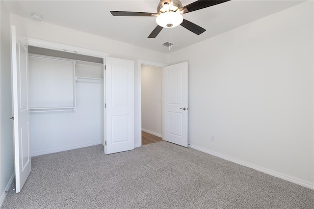 unfurnished bedroom featuring light colored carpet, a closet, and ceiling fan